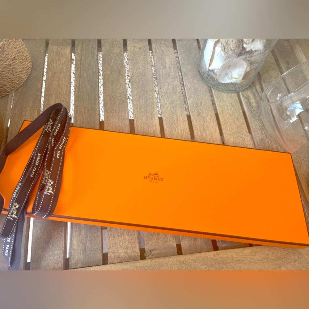 Hermès tie box with ribbon and white receipt card.